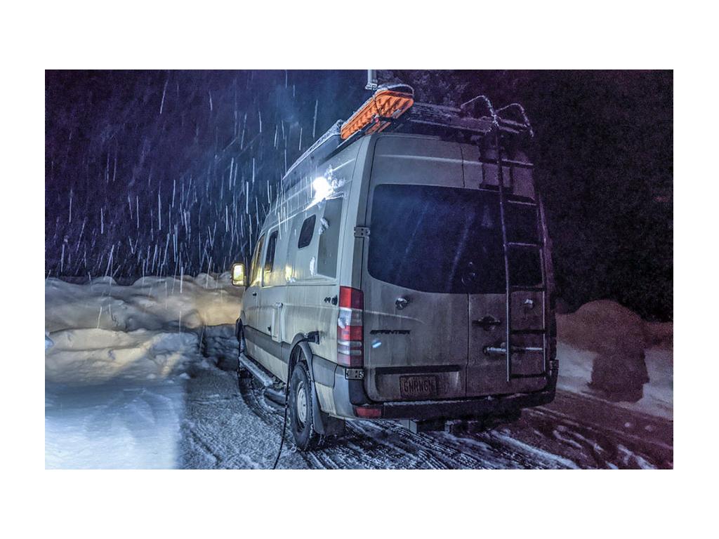 Gnar Wagon parked with snow falling around it while hooked up to electricity